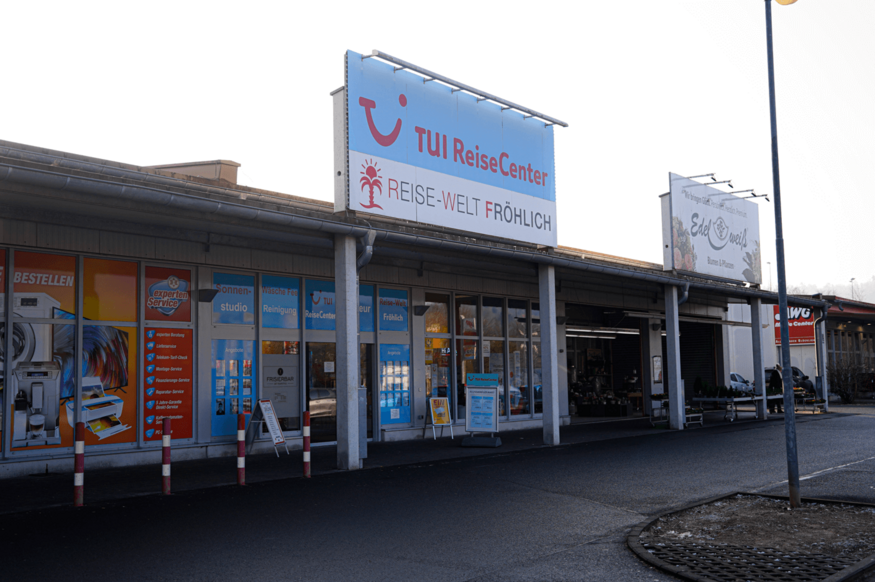 Breite Schaufensterfront der ReiseWelt Fröhlich mit TUI-Beschriftung im Einkaufszentrum.